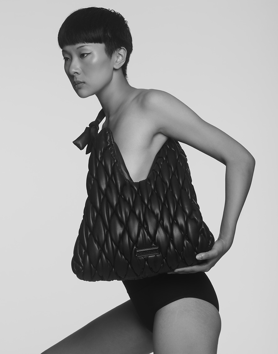 Black quilted handbag photographed on a model for a fashion accessories campaign in New York City
